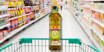 Olivový olej v nákupním košíku v supermarketu 