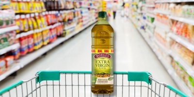 Olivový olej v nákupním košíku v supermarketu 