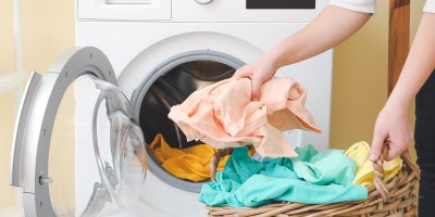 Žena vkládá prádlo do pračky