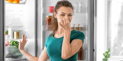 Žena si u ledničky drží nos
