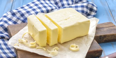 Nakrájená kostka másla na prkénku