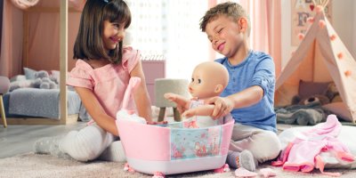 Kluk a holka si hrajou s panenkou a koupou ji