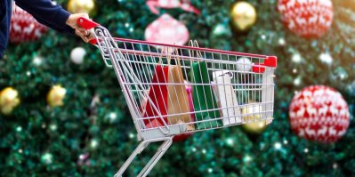 Žena tlačí nákupní vozík kolem vánočního stromečku