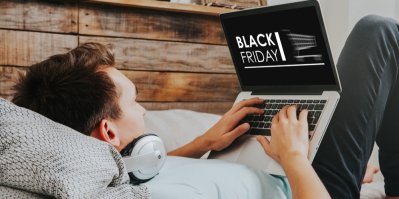 Muž píše na notebooku, kde je nápis Black Friday