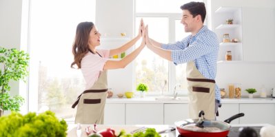 Muži se ženou si plácají rukama v kuchyni