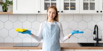 Žena stojí v gumových rukavicích v kuchyni