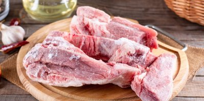 Zmrzlé maso na dřevěném prkénku