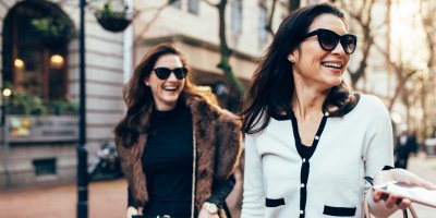 Dvě smějící se ženy v luxusním oblečení