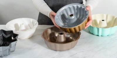 Žena porovnává různé formy na bábovku
