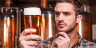 Muž drží v pivovaru sklenici s pivem