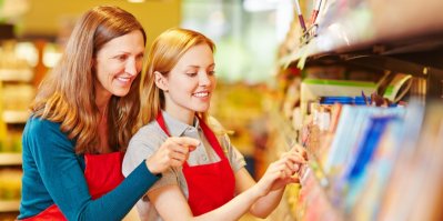 Dvě ženy kontrolují regál v supermarketu