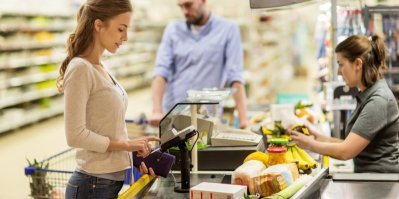 Žena platí u pokladny v supermarketu