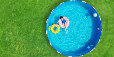Pohled seshora na ženu v kulatém bazénu na zahradě