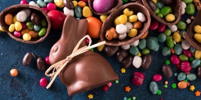 Čokoládový zajíček a vajíčka, kolem sladké barevné cukrovinky