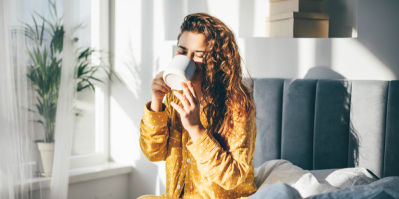 Žena pije kávu v posteli