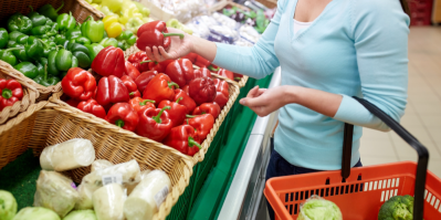 Žena si vybírá v supermarketu červené papriky