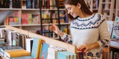 Žena si v knihkupectví prohlíží knihy