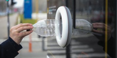 Ruka dává PET lahev do automatu na ulici