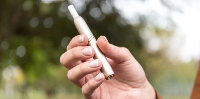 Ruka drží zařízení na nahřívaný tabák