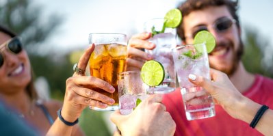 Mladí lidé si připíjí sklenicemi s alkoholem