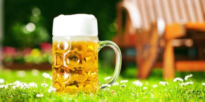 Sklenice piva položená na trávníku