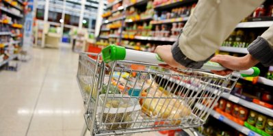 Žena tlačí nákupní vozík v supermarketu
