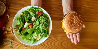 Jedna ruka držící salát, druhá hamburger