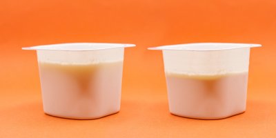 Dva kelímky jogurtu, v jednom je menší množství