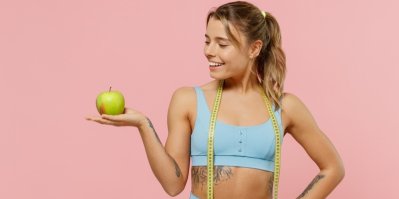 Žena s centimetrem kolem krku drží jablko