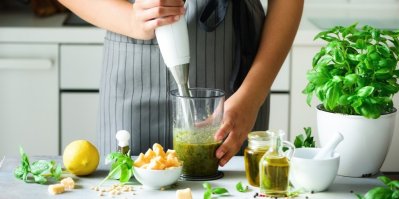 Žena vyrábí tyčovým mixérem pesto