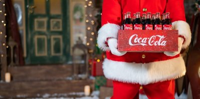 Santa Claus držící krabici s lahvemi Coca-Coly