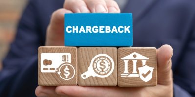 Dřevěné kostky se symboly na dlani, na jedné je napsáno chargeback