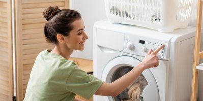 Mladá žena zapíná pračku