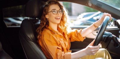 Smějící se žena řídí auto