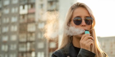 Mladá žena kouří e-cigaretu