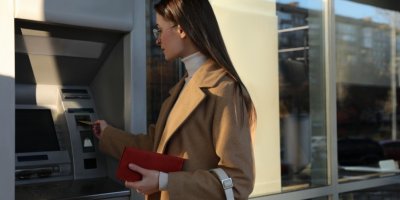 Žena, vybírající peníze z bankomatu