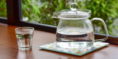 Horká voda ve skleněné konvici a sklenici
