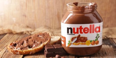 Nutella, vedle tabulka čokolády a krajíc chleba natřený Nutellou