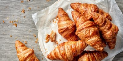 Několik croissantů na sobě, naskládaných na bílém talíři