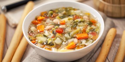 Polévka minestrone, servírovaná v bílé misce