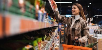 Usměvavá mladá žena nakupuje v supermarketu