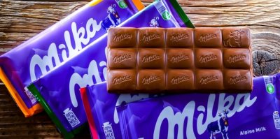 Čokoláda Milka bez obalu leží na dalších Milka čokoládách v obalech