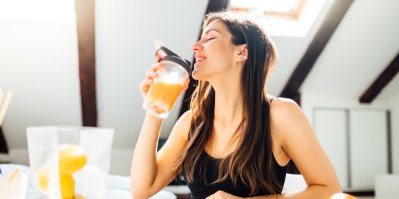 Mladá žena pije proteinový shake