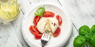 čerstvá burrata na talířku s rajčaty a bazalkou