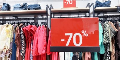 Cedule v obchodě s oblečením, která ukazuje slevu 70 %