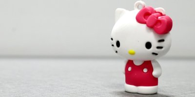 Postavička Hello Kitty sedí na červeném křesle na podstavci