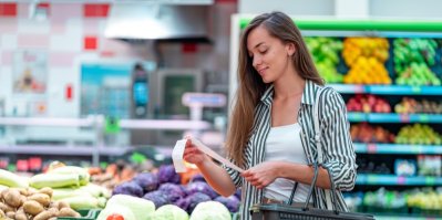 Žena v supermarketu u regálu se zeleninou