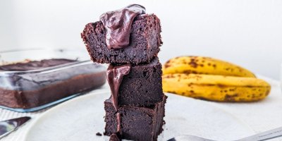 3 kostky banánového brownies naskládané na sobě, servírované na bílém talíři