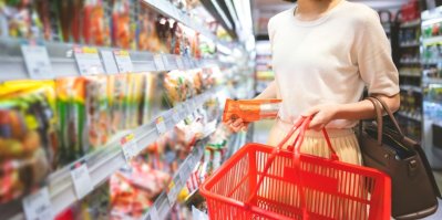Žena nakupuje v supermarketu s košíkem v ruce