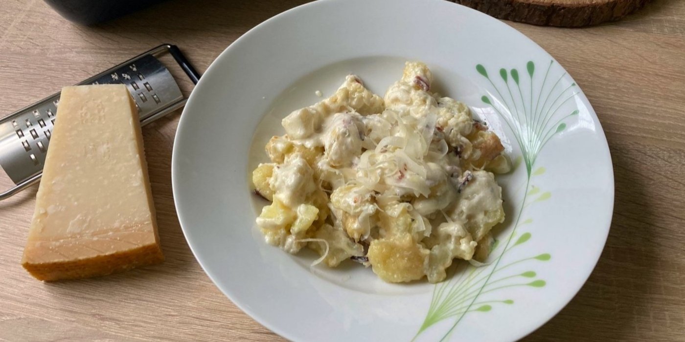 Zapečené gnocchi s květákem, servírované na bílém talíři